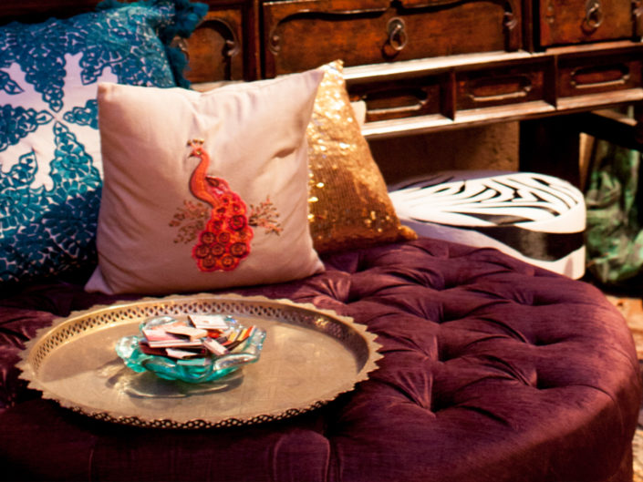 Lounge space, inspired decor, red lounge vignette, peacock pillow, gold pillow, blue pillow, wooden dresser, gold tray, los angeles event producer, LA photoshoot