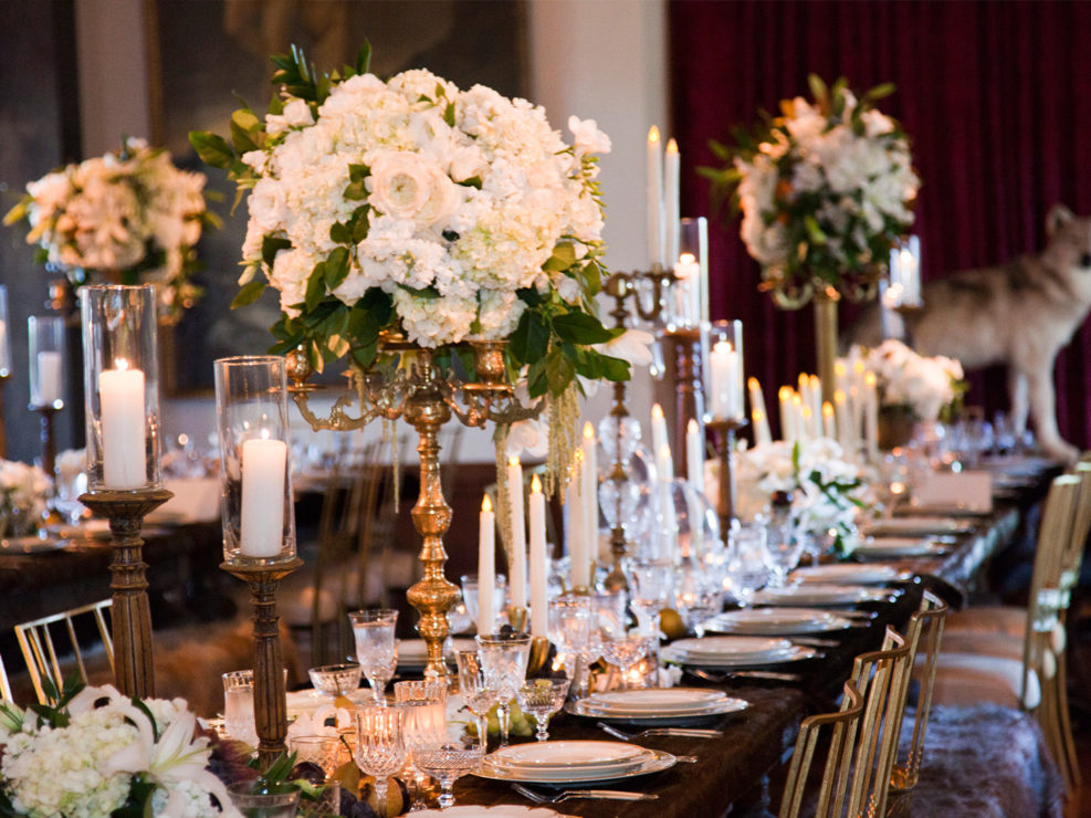 heaven and hell wedding, dinner tablescape, table top decor, heaven decor, white florals and accents, themed wedding, brass candelabras, stuffed wolf, gold chairs, kristin banta weddings and special events